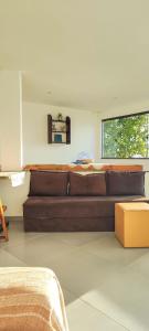 a brown couch in a living room with a window at Apartamento pé na areia com vista para o Mar de Itaipu in Niterói