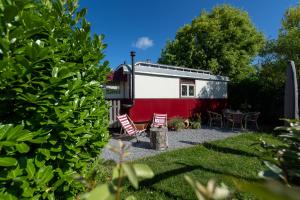 a red and white trailer with chairs and a table at De Wagen in Egmond-Binnen