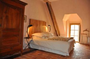 een slaapkamer met een bed met een houten hoofdeinde bij Domaine du Ris de Feu in Chalais