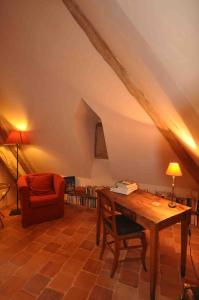 a living room with a wooden table and a chair at Domaine du Ris de Feu in Chalais