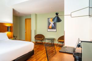 Habitación de hotel con cama y escritorio con ordenador portátil en Hôtel Casón del Tormes by HappyCulture, en Madrid