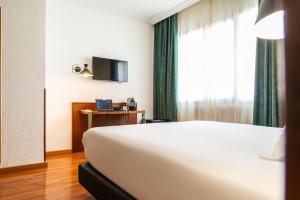 Habitación de hotel con cama blanca y ventana en Hotel Casón del Tormes by HappyCulture en Madrid