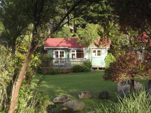 a white house with a red roof in a yard at The Sandcastle in Pohara