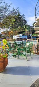 a green table and chairs sitting on a patio at Apartamento pé na areia com vista para o Mar de Itaipu in Niterói