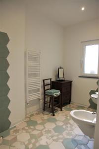 ein Badezimmer mit einem Stuhl, einem Waschbecken und einer Badewanne in der Unterkunft La Pezzuola 52 in Sopralacroce