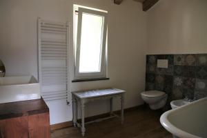 ein Bad mit einem Waschbecken, einem WC und einem Fenster in der Unterkunft La Pezzuola 52 in Sopralacroce