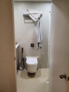 uma casa de banho com WC e toalhas penduradas na parede em Serene Home Stay em Bangalore