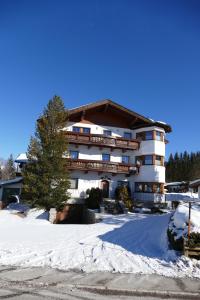 un gran edificio con nieve delante en KREUZHOF Seefeld en Seefeld in Tirol