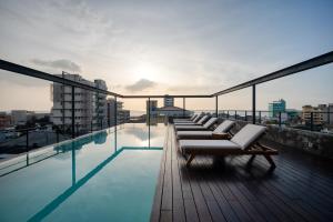 einen Pool auf dem Dach mit Liegestühlen auf dem Dach in der Unterkunft Taprobane House in Colombo