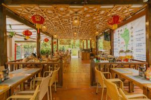 a restaurant with wooden tables and chairs and a menu at Valentina Resort & Spa Phu Quoc in Phú Quốc