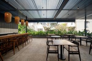 um restaurante com mesas, cadeiras e plantas em Taprobane House em Colombo