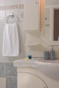 a bathroom with a white toilet and a sink at Rodanthi Hospitality in Kalamaki