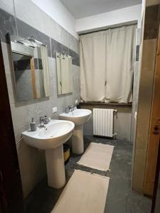 Baño con 2 lavabos y espejo en Villa Ambra B&B Siviglia, en Vermezzo