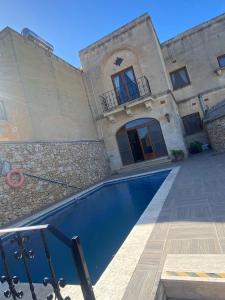 una casa con piscina di fronte a un edificio di Ta Marie Farmhouse, Ghasri Gozo a Għasri