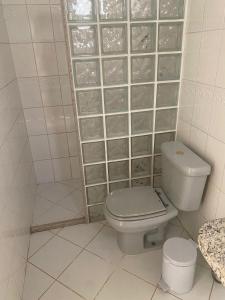 La salle de bains est pourvue de toilettes et d'un mur avec des blocs de verre. dans l'établissement Quarto Casal, Wi-Fi, Piscina, Praia, à Vila Velha