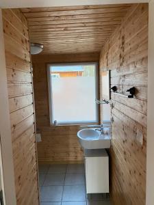 baño con lavabo y ventana en Bungalow WALD & SAND direkt am Strand en Dranske