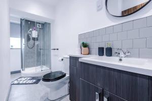 La salle de bains est pourvue de toilettes, d'un lavabo et d'une douche. dans l'établissement Elegant & Comfortable 1-BR Flat by Amazing Spaces Relocations Ltd, à Warrington