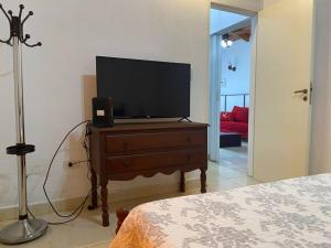telewizor na komodzie w sypialni w obiekcie Casa Pellegrini w mieście Posadas
