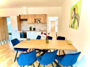 a kitchen with a wooden table and blue chairs at Apartmán č.5 v bankovním domě in Kutná Hora