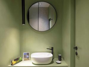 bagno con grande lavandino bianco e specchio di Hoppersgr- Amazing apt in the heart of Athens - 2 ad Atene