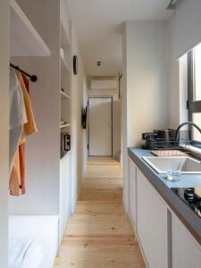 a kitchen with white counters and a wooden floor at Hoppersgr- Amazing apt in the heart of Athens - 2 in Athens