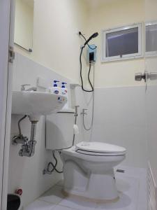 Baño blanco con aseo y lavamanos en New Tropical Inspired Home, en Cagayan de Oro