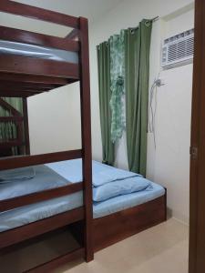 1 dormitorio con 2 literas y ventana en New Tropical Inspired Home, en Cagayan de Oro