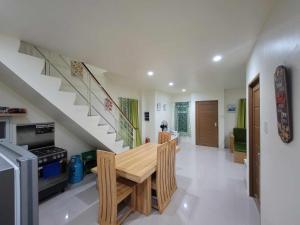 a dining room with a table and a staircase at Air-Conditioned Living Room and Bedrooms in Cagayan de Oro