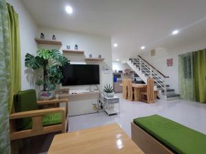 a living room with a flat screen tv and a staircase at Air-Conditioned Living Room and Bedrooms in Cagayan de Oro