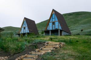 a house with a pointed roof on top of a hill at Focus Point Drakhtik - Green Cabin in Drakhtik