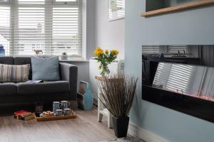 a living room with a couch and a flat screen tv at Fully refurbished holiday cottage in Rhosneigr in Rhosneigr