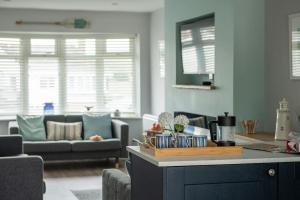 a kitchen and living room with a couch and a table at Fully refurbished holiday cottage in Rhosneigr in Rhosneigr