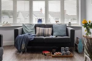 a living room with a gray couch in front of a window at Fully refurbished holiday cottage in Rhosneigr in Rhosneigr