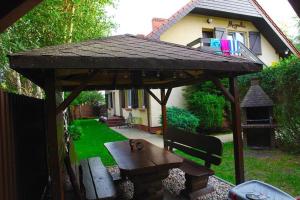 a wooden gazebo with a table and a bench at Apartment in Rowy with a garden in Rowy