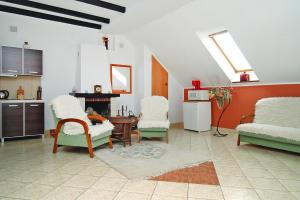 a living room with chairs and a table and a kitchen at Apartment in Rowy with a garden in Rowy