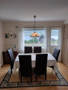 een eetkamer met een tafel en stoelen en een raam bij Romslig leilighet med flott utsikt over sjøen in Vestnes