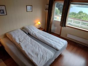 een bed in een kamer met een raam en een bed sidx sidx sidx bij Romslig leilighet med flott utsikt over sjøen in Vestnes