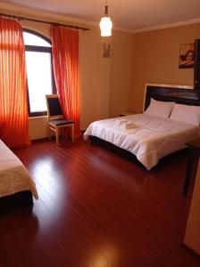 una camera d'albergo con due letti e una finestra di Ble Alb a Udënisht