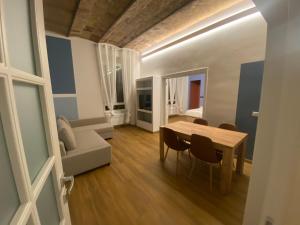uma sala de estar com uma mesa de madeira e cadeiras em Eutierra BLeisure Stay em Roma