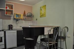 a kitchen with a counter and two bar stools at DayFlat Apartments Kremenchug in Kremenchuk