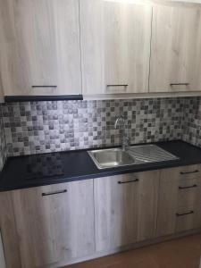 a kitchen with wooden cabinets and a sink at Sea&Park View in Skala Marion