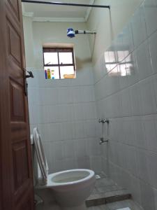 ein Bad mit einem WC und einem Fenster in der Unterkunft Serene Palace in Nairobi