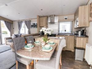 a kitchen and living room with a table and chairs at 13 Harlech Court in Prestatyn