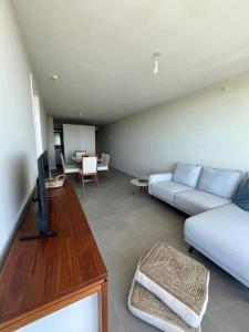 a living room with a couch and a tv at Alquiler Apto Punta Del Este in Punta del Este