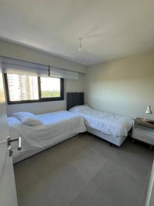 een slaapkamer met 2 bedden en een raam bij Alquiler Apto Punta Del Este in Punta del Este
