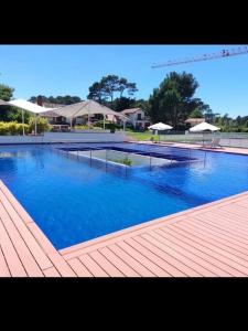 a large swimming pool with blue water and umbrellas at Alquiler Apto Punta Del Este in Punta del Este
