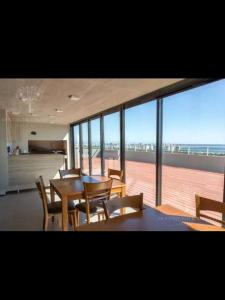 a dining room with tables and chairs and a view of the ocean at Alquiler Apto Punta Del Este in Punta del Este