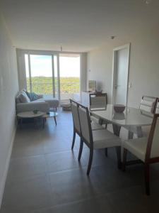 a living room with a table and chairs and a couch at Alquiler Apto Punta Del Este in Punta del Este