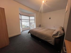 a bedroom with a bed and a large window at OYO Arcadia By Habitat101 in Middlesbrough