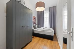 ベルリンにあるprimeflats - Big family apartment Schönebergのベッドルーム1室(ベッド1台付)、大きなキャビネットが備わります。